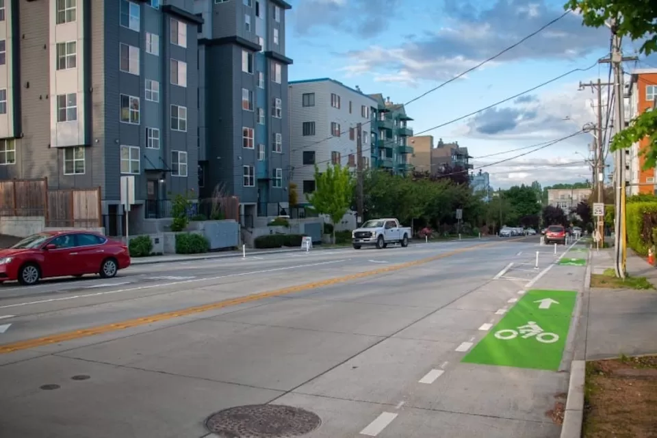 Green painted bike lane on street next to modern mid-rise apartment buildings in Seattle, Washington.